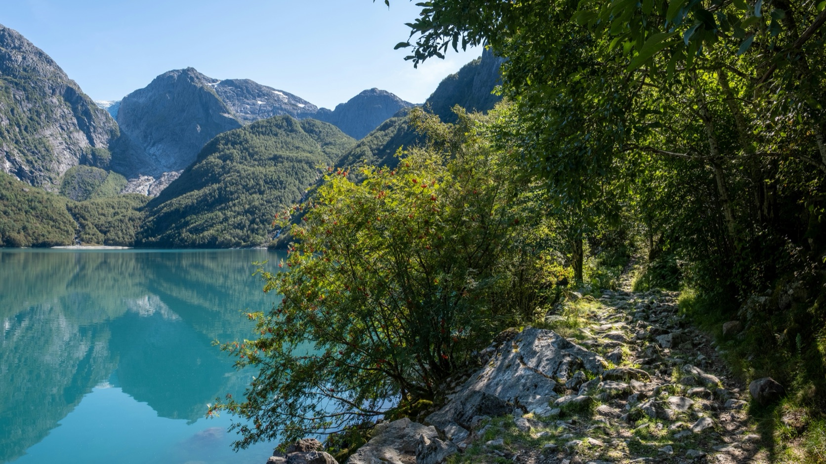 Bondhusvatnet sett fra stien langs bredden, med turkist vann og Bondhusbreen innerst i dalen