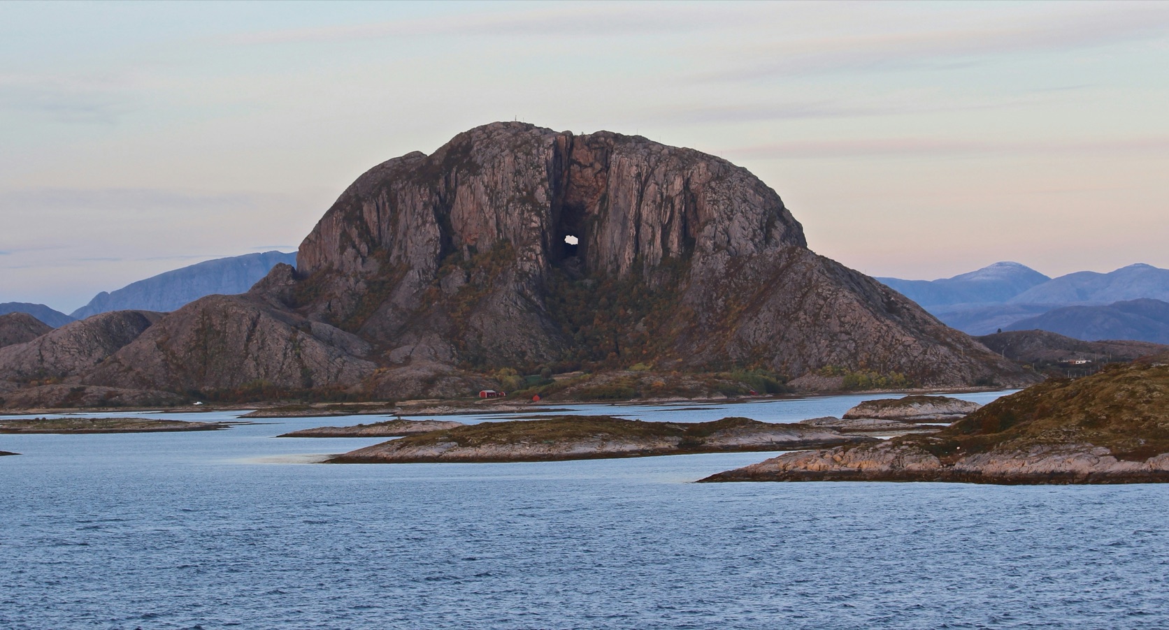 Torghatten sett fra sjøen, med hullet tvers gjennom fjellet og holmer i forgrunnen