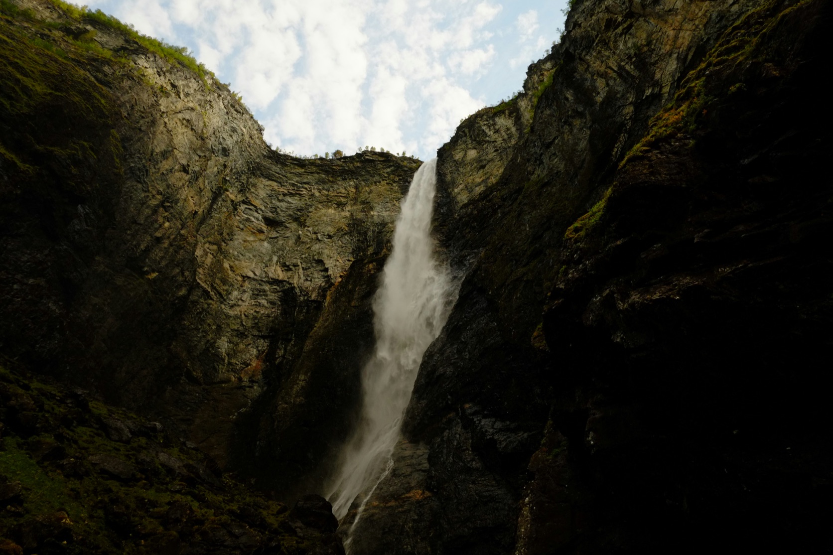 Vettisfossen faller fra et skar i fjellkanten ned i en trang og mørk kløft
